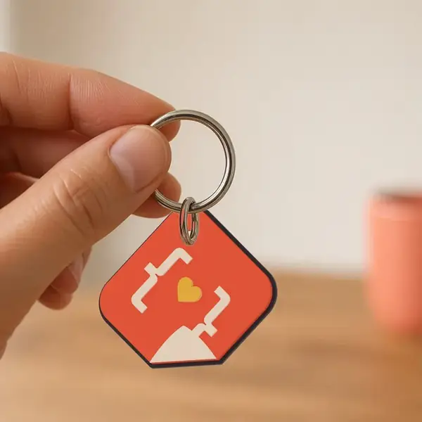 3D printed StickerCon logo keychain, about 46 mm, hanging at an angle from a split ring.